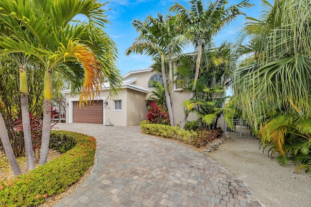 210 14th St, Key Colony, FL 33051 - view of front of property with decorative driveway, a gate, a garage, and stucco siding