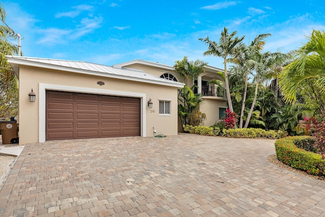 210 14th St, Key Colony, FL 33051 - view of front of property featuring decorative driveway, metal roof, a balcony, and stucco siding