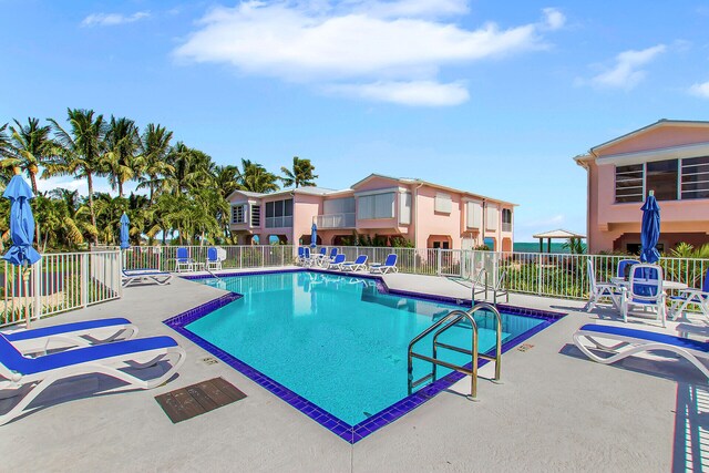 pool with a patio area and fence