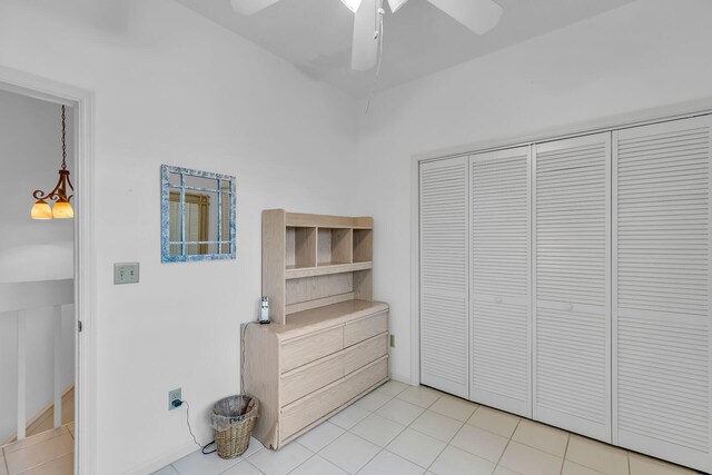 unfurnished bedroom with a closet, light tile patterned flooring, and a ceiling fan