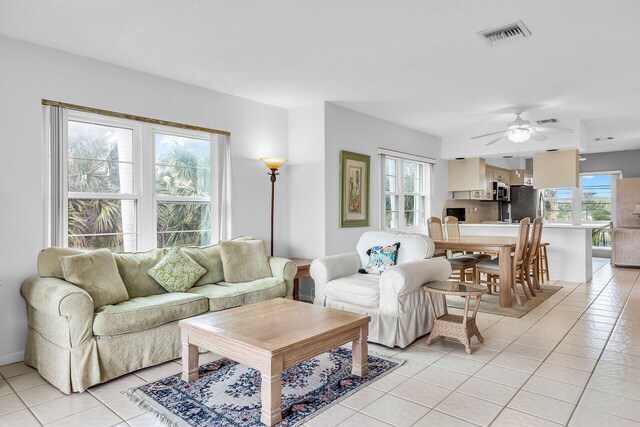 living area with light tile patterned floors, ceiling fan, and visible vents