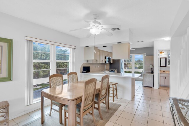 dining area with light tile patterned floors, visible vents, and a ceiling fan