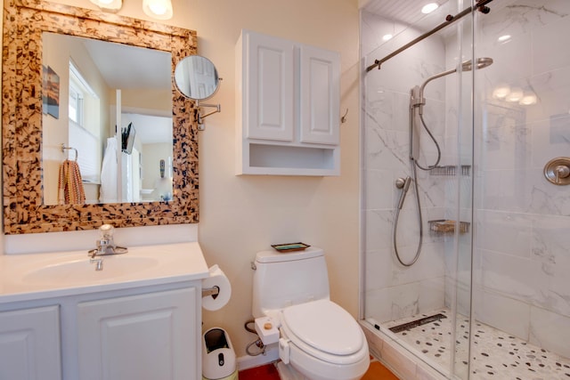 bathroom with a stall shower, vanity, and toilet