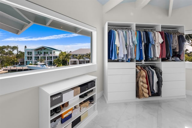 spacious closet with marble finish floor and beamed ceiling