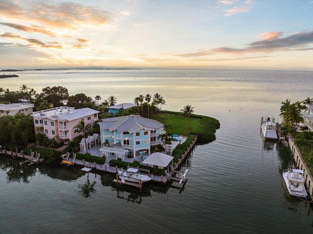 aerial view at dusk featuring a water view