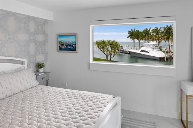 bedroom with a water view and baseboards