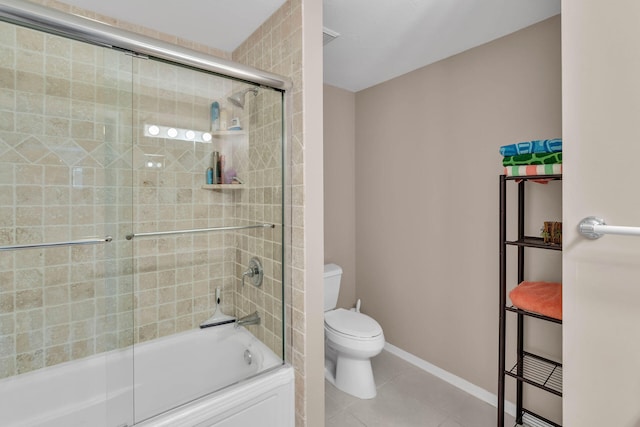 bathroom with baseboards, shower / bath combination with glass door, toilet, and tile patterned floors