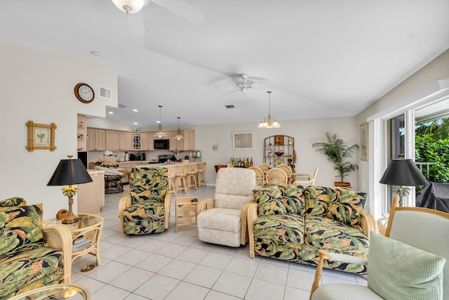 living area featuring light tile patterned floors, vaulted ceiling, visible vents, and ceiling fan with notable chandelier