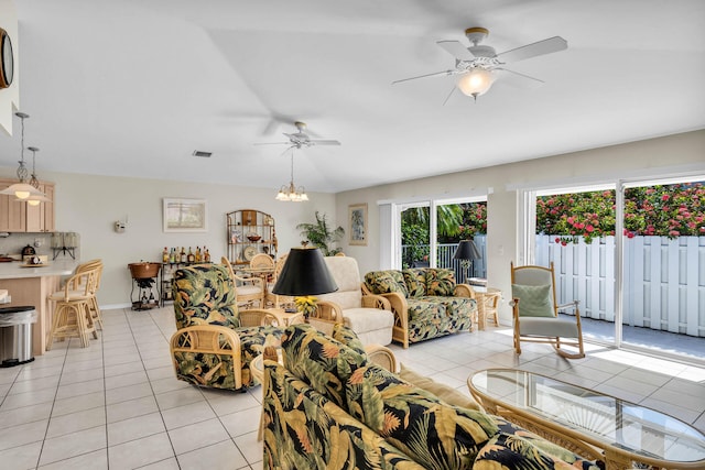 living room with light tile patterned floors, visible vents, and ceiling fan with notable chandelier