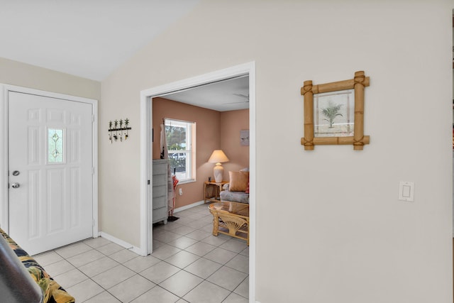 foyer entrance with lofted ceiling, baseboards, and light tile patterned floors