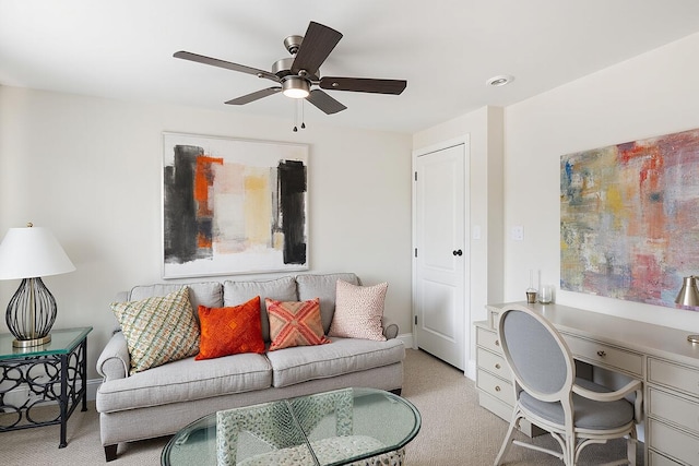 living room featuring light carpet, baseboards, and a ceiling fan