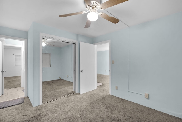 unfurnished bedroom with carpet floors, a closet, and a ceiling fan