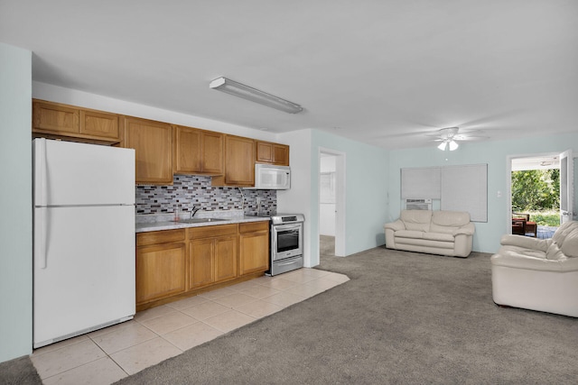 kitchen with light countertops, open floor plan, light carpet, a sink, and white appliances