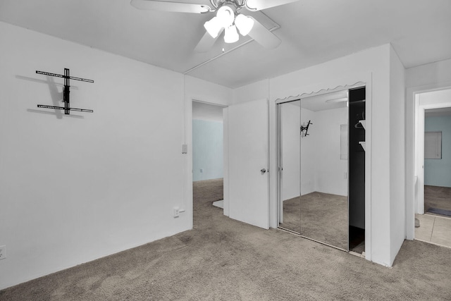 unfurnished bedroom featuring a closet, carpet flooring, and ceiling fan