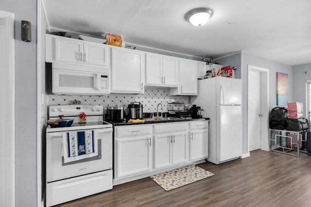 kitchen featuring dark countertops, white appliances, and white cabinets