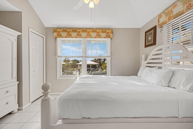 bedroom featuring a ceiling fan, lofted ceiling, baseboards, and light tile patterned floors