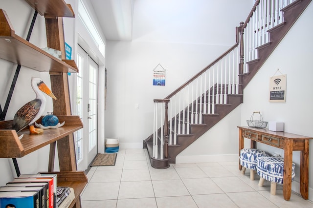 entrance foyer featuring tile patterned floors, stairs, and plenty of natural light