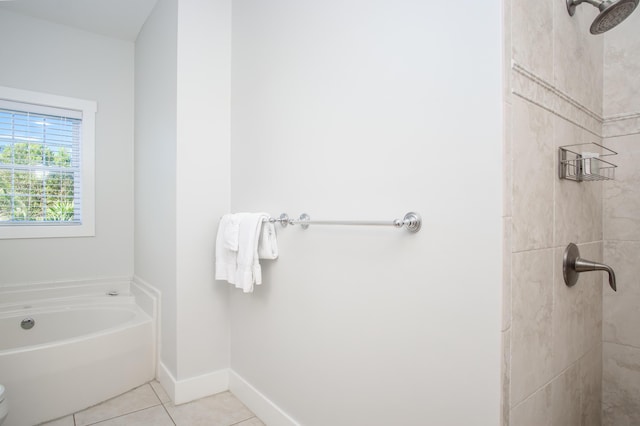 full bath featuring tile patterned floors, baseboards, tiled shower, and a garden tub