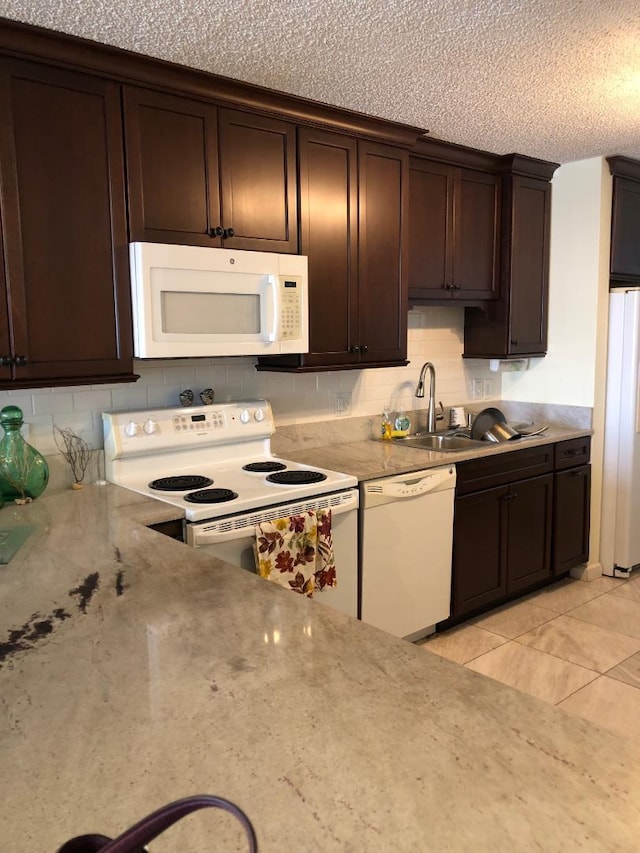 1901 Roosevelt Blvd Unit 404S, Key West, FL 33040 - kitchen with dark brown cabinetry, white appliances, backsplash, a sink, and a textured ceiling