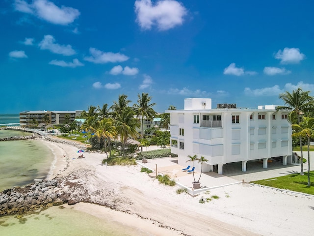 view of building exterior with a beach view and a water view