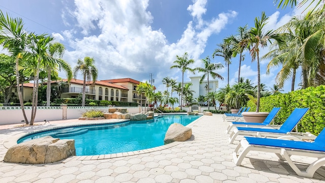 pool featuring fence and a patio area