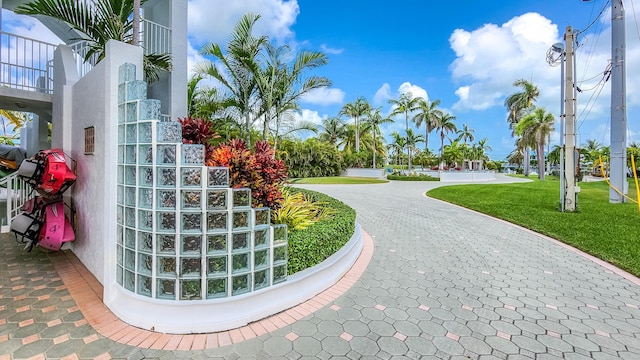 view of property's community with a lawn and decorative driveway