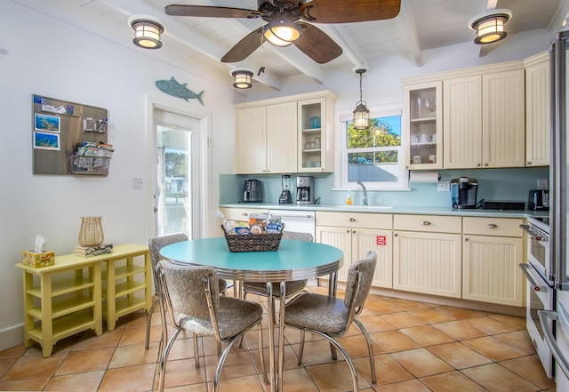 kitchen with glass insert cabinets, pendant lighting, light countertops, and beamed ceiling