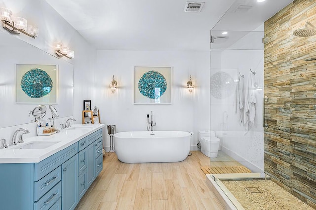 bathroom featuring visible vents, a sink, a walk in shower, and a freestanding bath