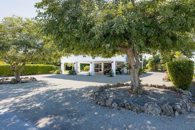 view of property hidden behind natural elements featuring covered porch