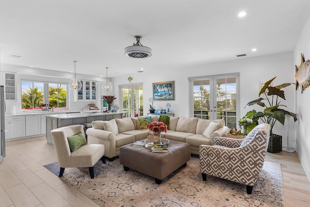 living area featuring recessed lighting, visible vents, and french doors