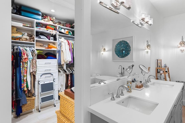 full bath with double vanity, a sink, and a spacious closet
