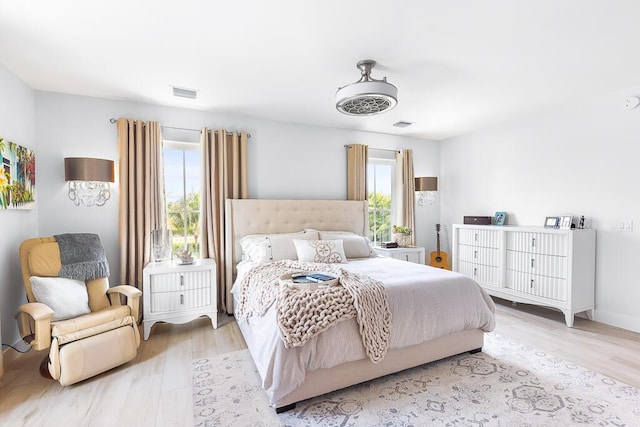bedroom featuring multiple windows, wood finished floors, and visible vents