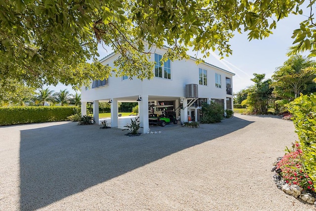 view of front of home with stairs, driveway, and a carport