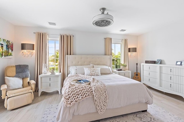 bedroom with light wood-style floors and visible vents