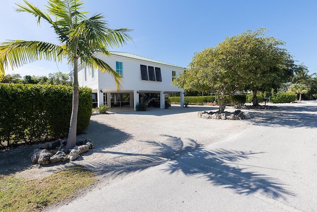 exterior space with metal roof, driveway, and a carport