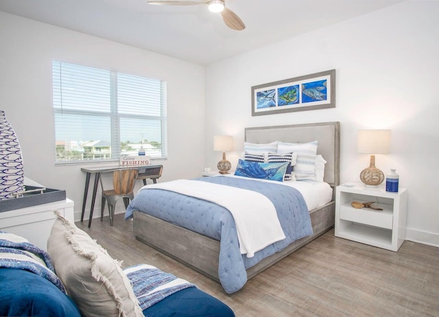 bedroom with ceiling fan, wood finished floors, and baseboards