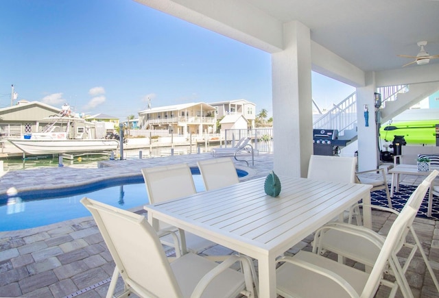 view of patio featuring a fenced in pool, area for grilling, a ceiling fan, stairs, and outdoor dining space