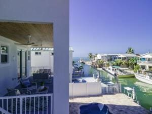 balcony featuring a water view and ceiling fan