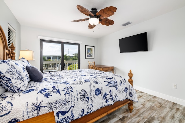 bedroom featuring a ceiling fan, visible vents, access to exterior, wood finished floors, and baseboards