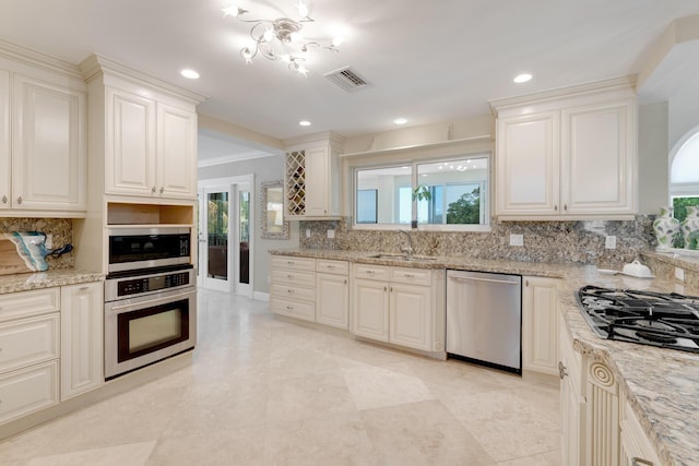 kitchen with a wealth of natural light, backsplash, visible vents, and stainless steel appliances