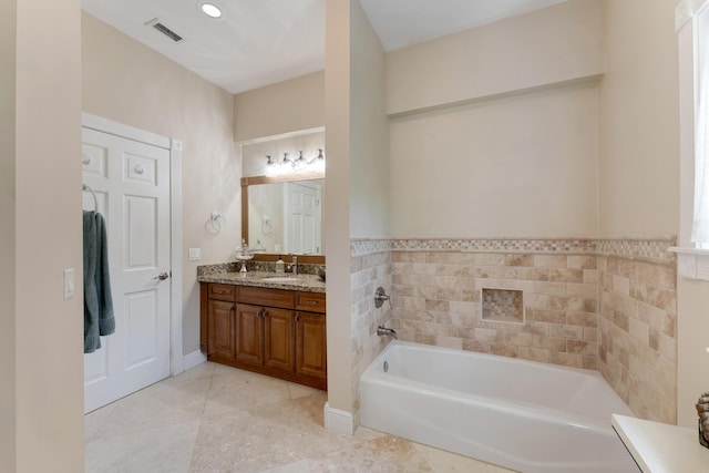 bathroom featuring a garden tub, vanity, tile patterned flooring, and visible vents