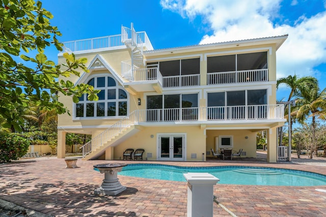 rear view of property featuring a patio area, stairway, french doors, and stucco siding