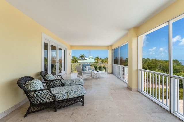 sunroom featuring french doors, baseboards, and a healthy amount of sunlight