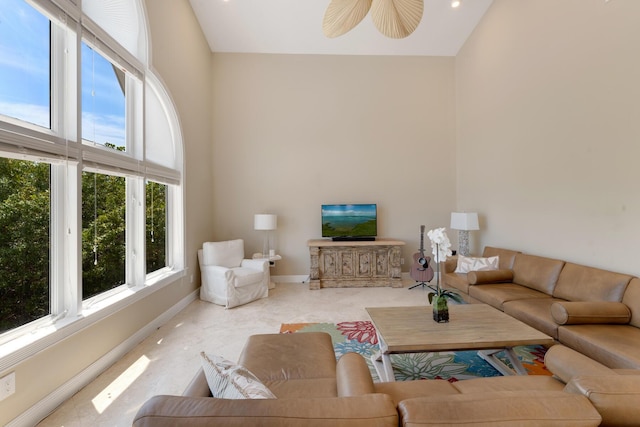 living area with high vaulted ceiling, plenty of natural light, and baseboards