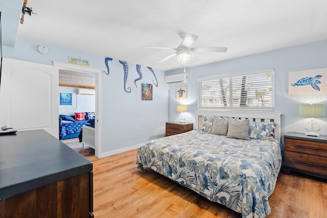 bedroom with baseboards, light wood finished floors, ceiling fan, and a wall mounted AC