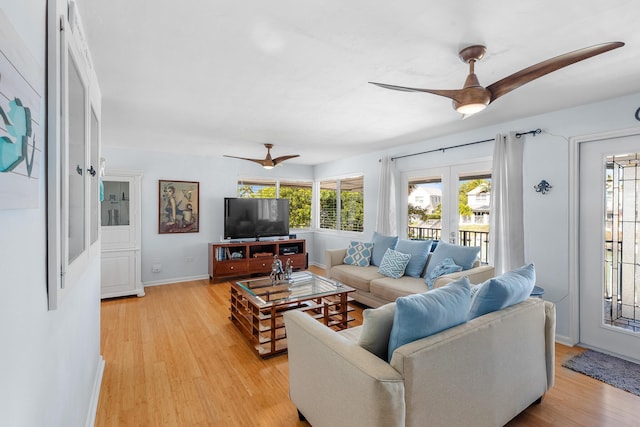 living room with light wood-style flooring, french doors, baseboards, and a ceiling fan