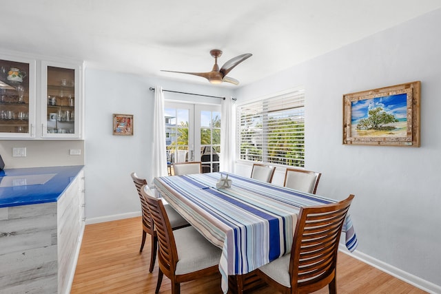 dining area featuring baseboards, light wood-style flooring, and a ceiling fan