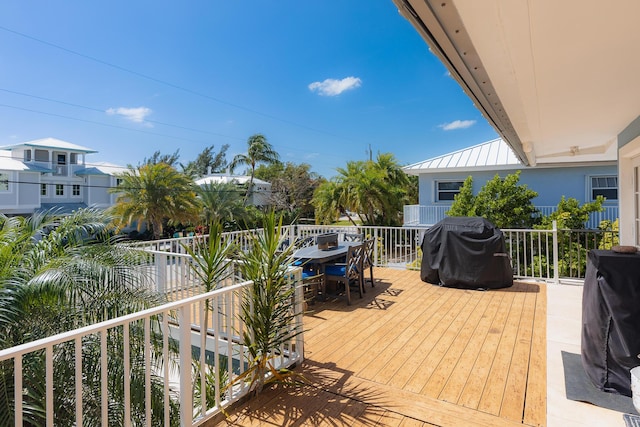 wooden terrace featuring area for grilling and outdoor dining area