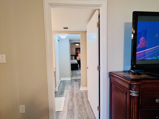 corridor with visible vents, baseboards, and wood finished floors