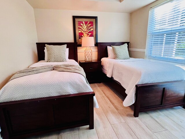 bedroom featuring a wainscoted wall and light wood-style flooring